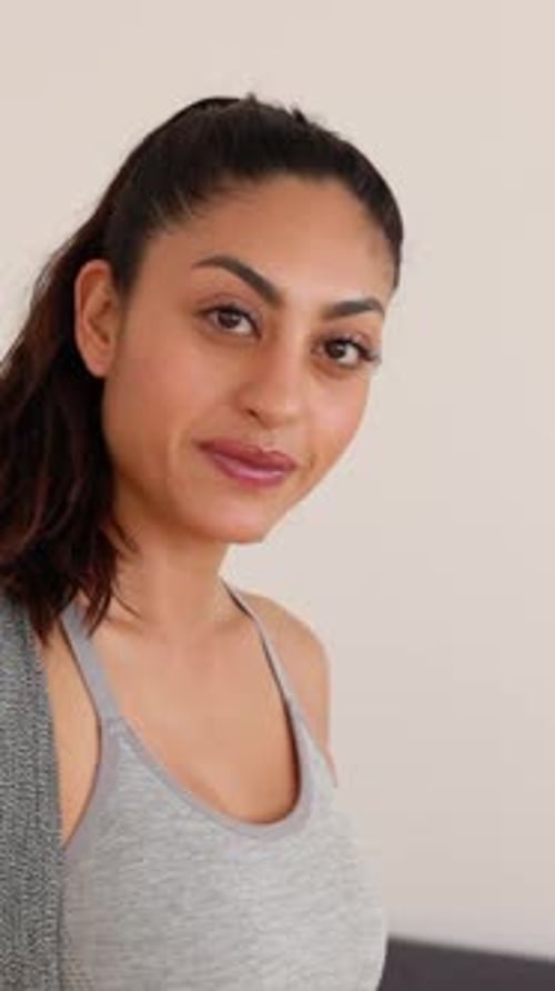 Portrait of Happy Young Fit Woman in Sportswear Holding Yoga Mat at Home