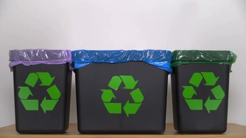 Recycling Bins Lined Up with Recycling Symbol