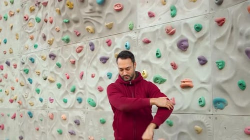 Man Stretching Arms at Indoor Rock Climbing Gym