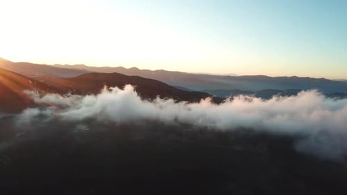 Drone Aerial View of Clouds Above Mount Evans, Colorado USA, on Sunset Sunlight Backlight