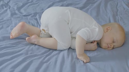 Baby Sleeping Peacefully in Bed on their Side