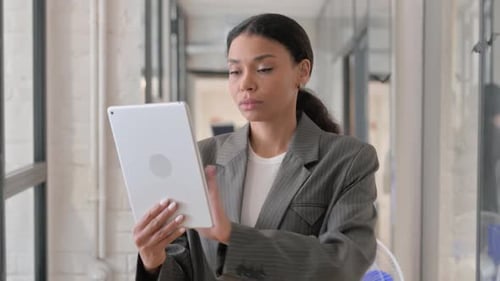 Young Woman Uses Tablet in Modern Office