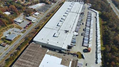 Large Commercial Distribution Storehouse with Many Semitrucks Unloading and Uploading Retail