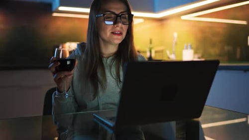 Woman Videocalling with Wine in Kitchen at Night