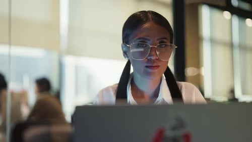 Woman Looking At The Camera While Working On Her Laptop