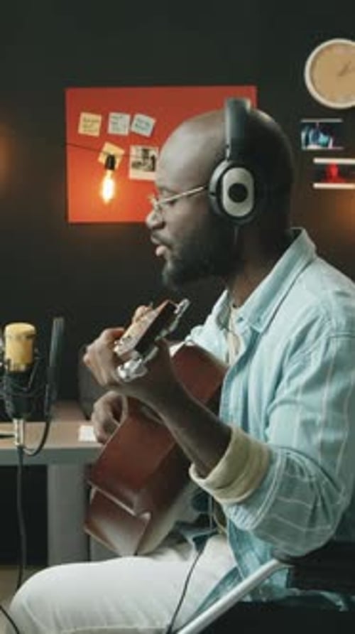 African American Man with Disability Performing Guitar Music in Home Studio