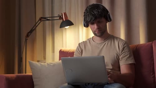 Young Adult Uses Laptop on a Couch
