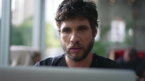 Ein nachdenklicher Mann, der vor dem Laptop nachdenkt. Nachdenkliche Person schaut auf den Computerbildschirm
und grübelt