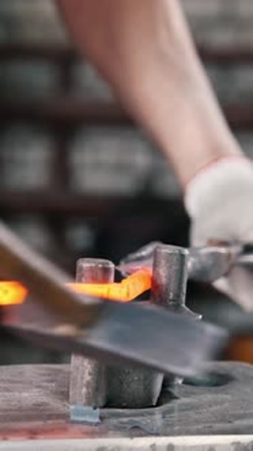 Close Up View Hands of Blacksmith with Gloves in Forge