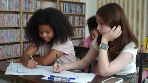 Students Collaborating on Assignment in School Library