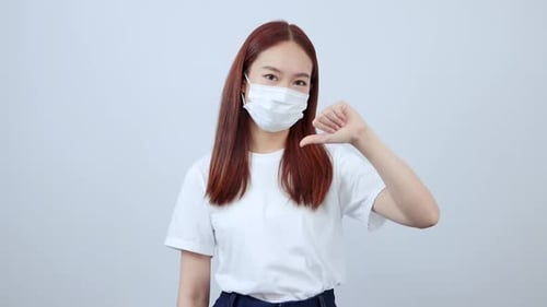Woman in Mask Gives Double Thumbs Down