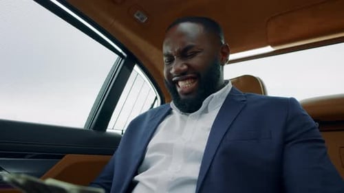 Excited Man Holding Money in a Car