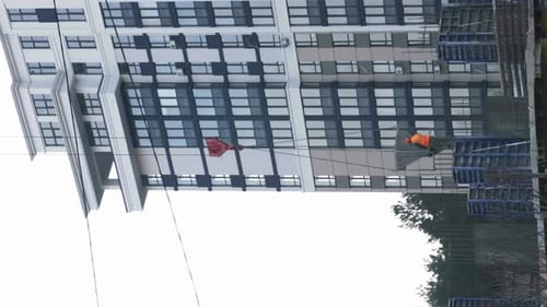 Construction crane and workers working at building site. Vertical video
