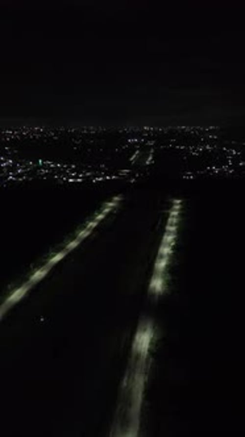Vertical drone footage of deserted street at night
