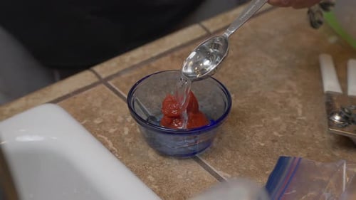 Adding vinegar to tomato paste for ingredients in a homemade recipe - isolated slow motion