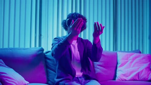 Man Using VR Headset in Neon Lit Room
