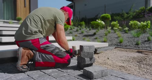 Laying Stone Pavers in a Modern Outdoor Garden in Bright Afternoon Sunlight