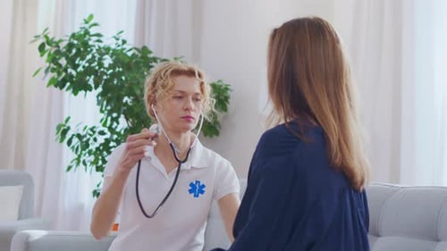 Attentive Doctor Listening to Patient Heartbeat at Home