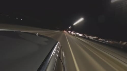 Imágenes de lapso de tiempo de un automóvil conduciendo de noche. Vista trasera desde el exterior