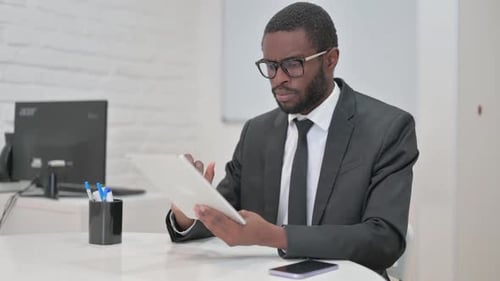 Young Adult Uses Tablet at Bright Desk