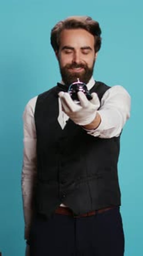 Man Rings Silver Desk Bell in Studio Setting
