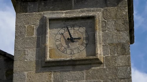 Static detailed view of clock tower in stone of historic church of Santa María de Mugares in Toén, O