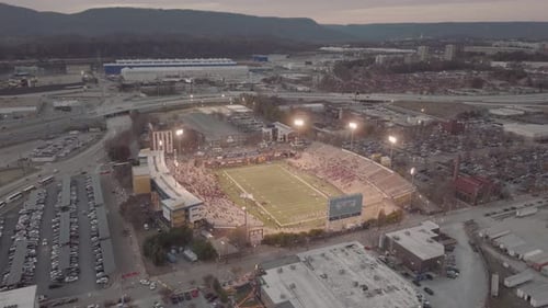Aerial shot rotating around stadium with a sports game and crowds.