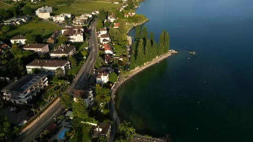 Reveal drone shot of Lavaux terraced vineyards and Lake Geneva during the day near Lutry