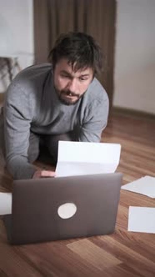 Man Paying Bills Online at Home Using Laptop and Documents Financial Management Remote Payment