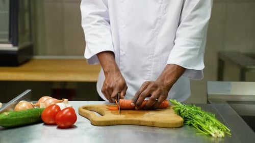 Chef Slicing Carrots in Commercial Kitchen
