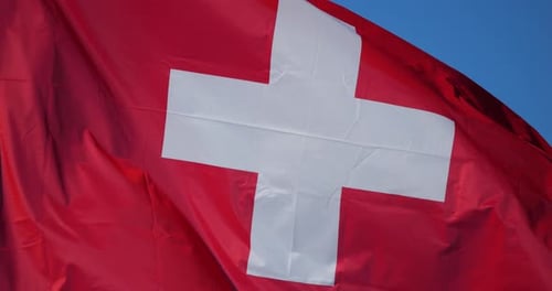 Red Flag with White Cross Waving in the Wind
