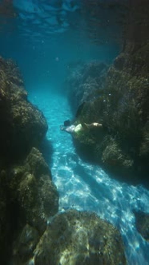 Young Adult Swimming in Turquoise Underwater Channel
