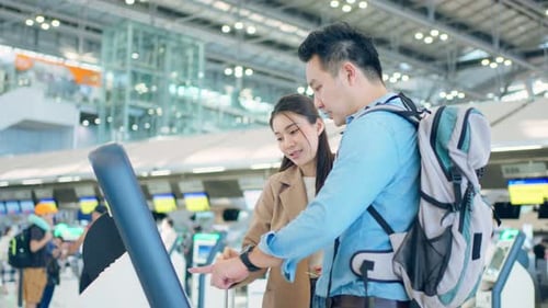 Asian young couple passenger check in at counter in airport terminal.
