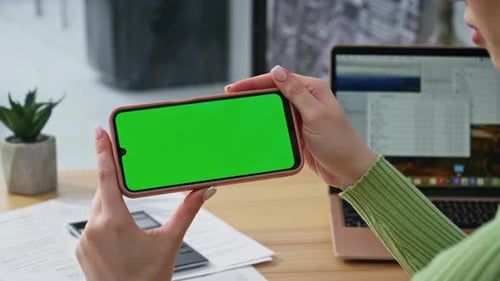 Woman Holds Smartphone with Green Screen Horizontally
