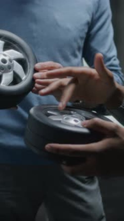 People Inspecting Car Wheel Design Prototypes