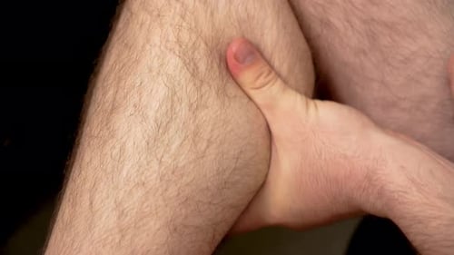 Man Massaging Tired Leg Muscles Close Up Unrecognizable Male Relieving Fatigue in Leg Muscles with