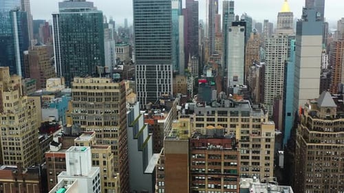 Aerial view flying in middle of buildings in Midtown, cloudy day in New York city