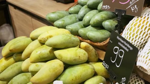 Man Takes Mango in Grocery Supermarket From Fruit Shelf Male Customer Hand Buy Fresh Ripe Fruit in