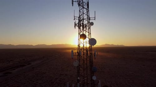 Aerial: Cell tower at sunset close up. Advanced technology in Arizona desert.