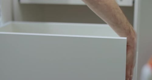 Man Repairs a Drawer in the Kitchen a Man is Assembling Kitchen Furniture Pushing a Drawer Into a