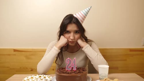 Sad Woman Sits Alone with Birthday Cake