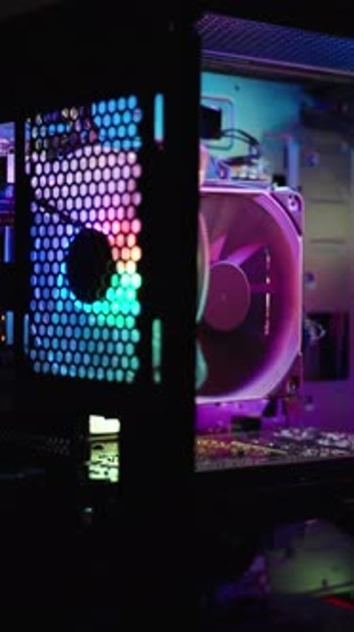 Vídeo vertical. Funda para PC de sobremesa para videojuegos con iluminación arcoíris. La luz RGB se proyecta en la pared.