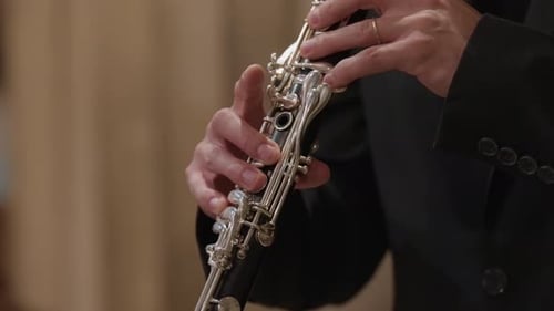 close view of clarinet keys moving in warm indoor light