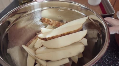 Preparing Potato Wedges on Baking Sheet in Oven