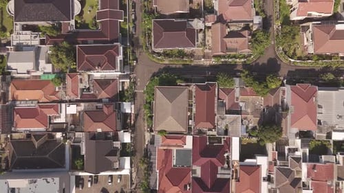 Aerial top-down ascending shot over residential neighborhood in Indonesia—revealing cityscape, rooft