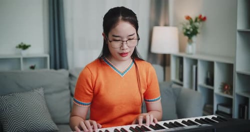 Young Woman Plays Electric Piano at Home
