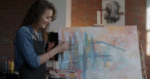 Artist Painting Abstract Canvas in Bright Studio