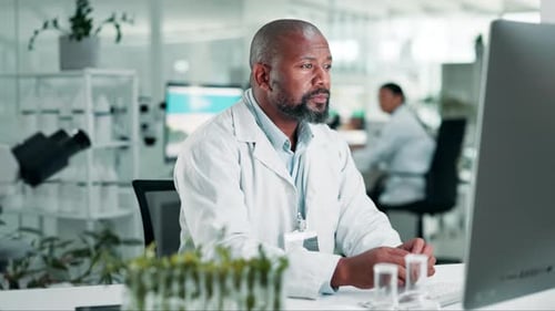Man Typing at Computer in Modern Laboratory