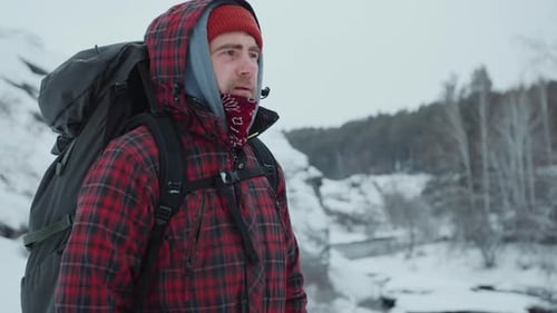 Backpacker Contemplating Winter Nature from Mountain Peak