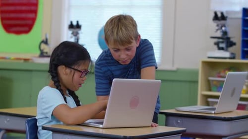 Elementary school children working together on laptop